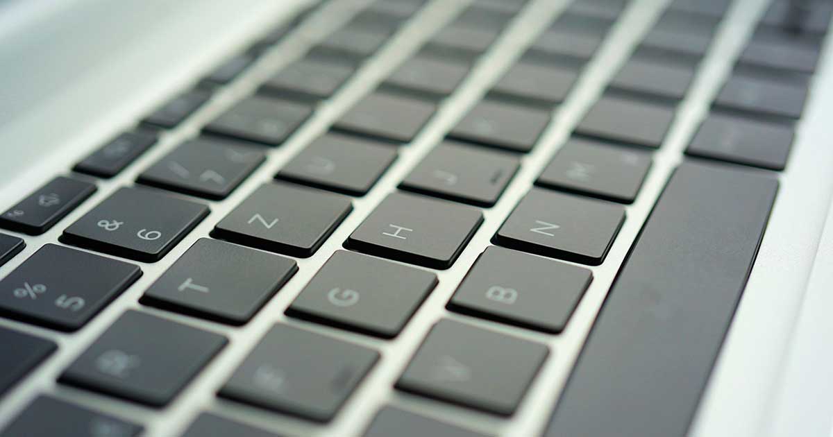 Nahaufnahme einer Laptop-Tastatur mit schrägem Blickwinkel, Fokus auf den Buchstabentasten.