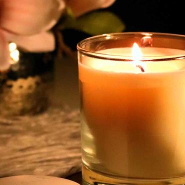 Kerze steht vor einem Strauß Magnolien