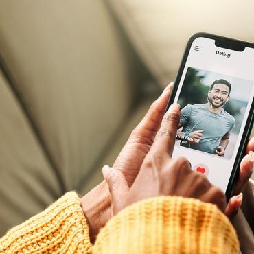 Person nutzt eine Dating-App auf dem Smartphone und sucht nach passenden Kontakten.