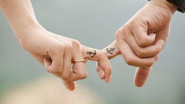 Bild zeigt Hände eines Paares mit Anker-Tattoo