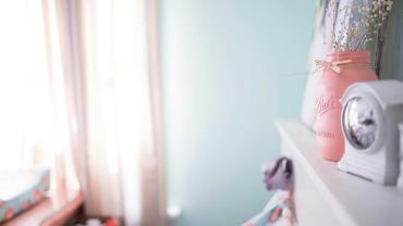 Schrank in einem Kinderzimmer, auf dem eine Kinderuhr steht