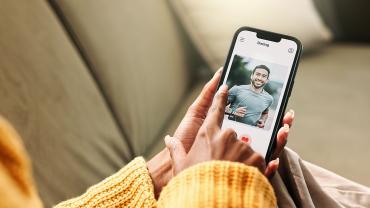 Person nutzt eine Dating-App auf dem Smartphone und sucht nach passenden Kontakten.