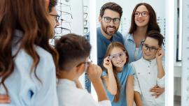 Familie probiert gemeinsam Brillen beim Optiker an
