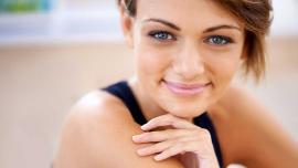 Frau mit gepflegter Haut und natürlichem Teint lächelt in die Kamera