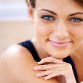 Frau mit gepflegter Haut und natürlichem Teint lächelt in die Kamera
