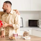 Paar in der Küche mit kleinem Geschenk – aufmerksamer Moment in der Beziehung