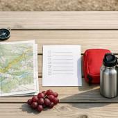 Packliste, Karte und Trinkflaschen für einen geplanten Familienausflug im Freien