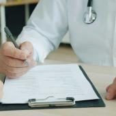 Arzt im Beratungsgespräch mit einem Patienten über die Behandlung chronischer Erkrankungen