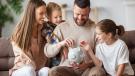 Glückliche Familie legt Geld in ein Sparschwein – Symbol für finanzielle Entlastung durch Elterngeld und Kinderfreibetrag
