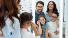 Familie probiert gemeinsam Brillen beim Optiker an