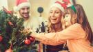 Familie schmückt gemeinsam den Weihnachtsbaum im Advent